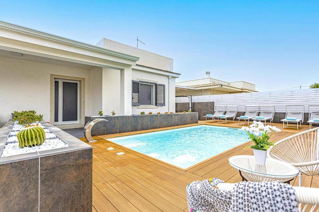 une piscine dans l'arrière-cour d'une maison dans l'établissement Villa Loredana by Villa Plus, à Santa Maria Del Focallo