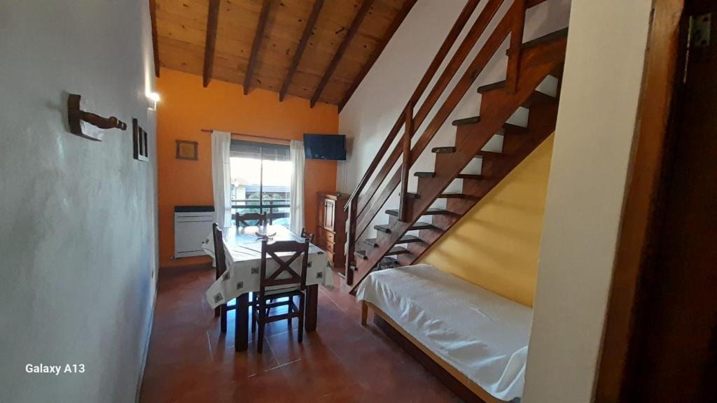 Zimmer mit einer Treppe, einem Tisch und einem Bett in der Unterkunft Departamentos Momo in San Bernardo