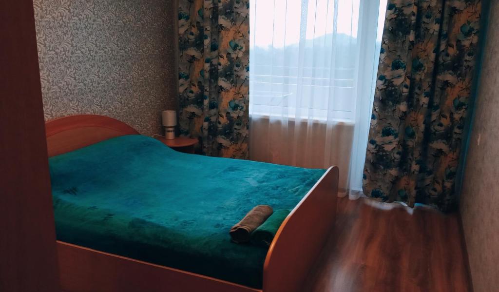 a bedroom with a bed with a wooden frame and a window at Apartmenti Saules stūris in Ventspils