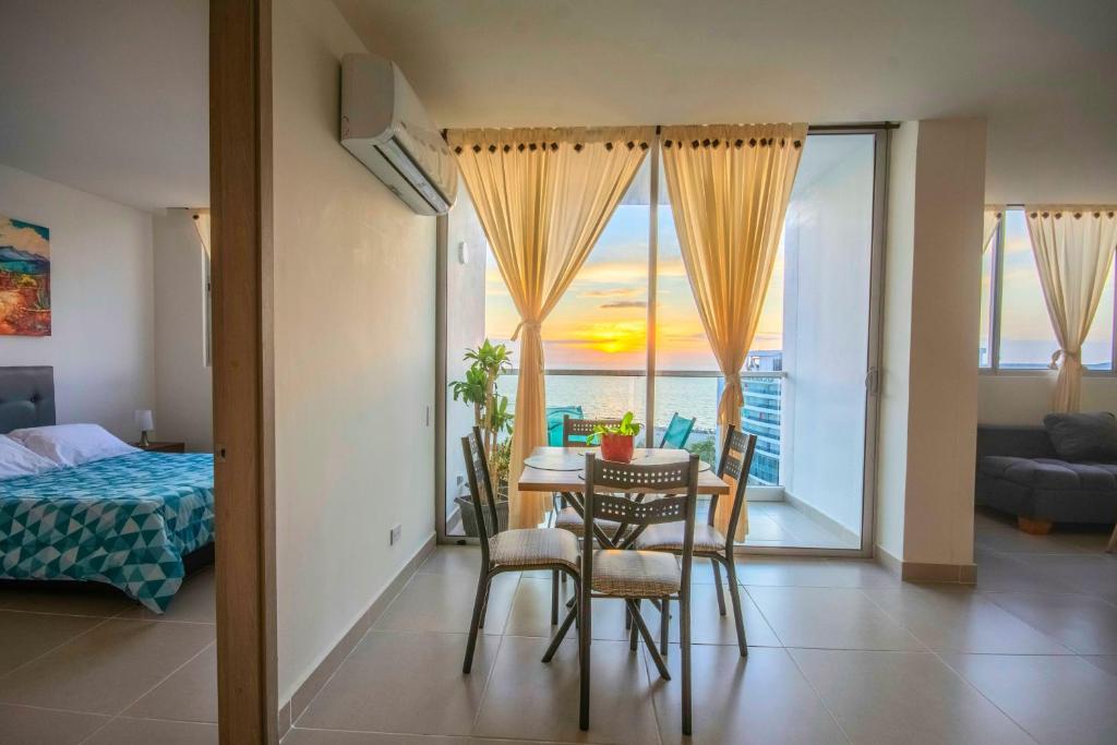 une pièce avec une table et des chaises et une chambre dans l'établissement Exclusivo apartamento en Cielo Mar-playa las Americas, con maravillosas vistas del atardecer de Cartagena, à Carthagène des Indes