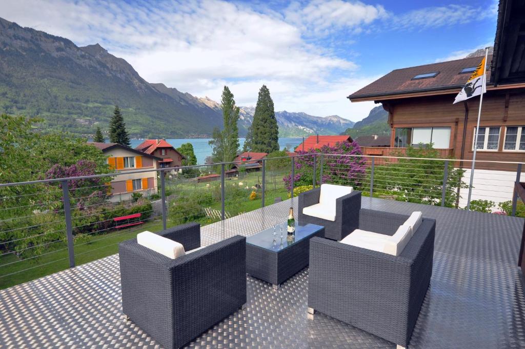 a patio with two chairs and a table on a balcony at Lake View Chalet in Bönigen