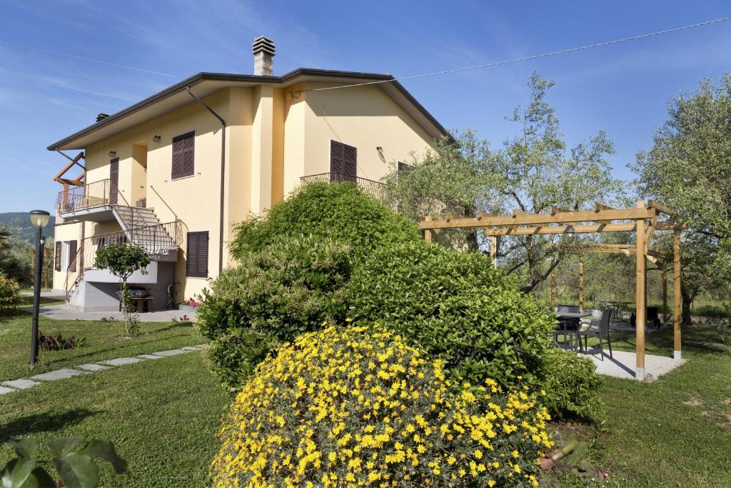 une maison avec un grand bush devant elle dans l'établissement L'OrtoBio, à Sarzana