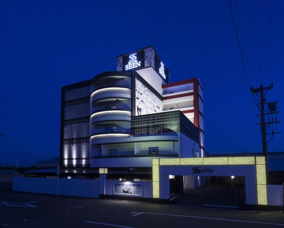 a building with a sign on top of it at night at HOTEL SEEN - OCEAN TERRACE - (Adult Only) in Taketoyo