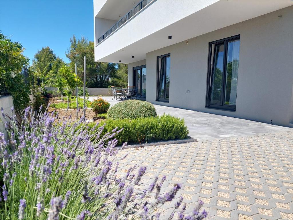 a house with purple flowers in front of it at Apartman Zlata in Pakoštane
