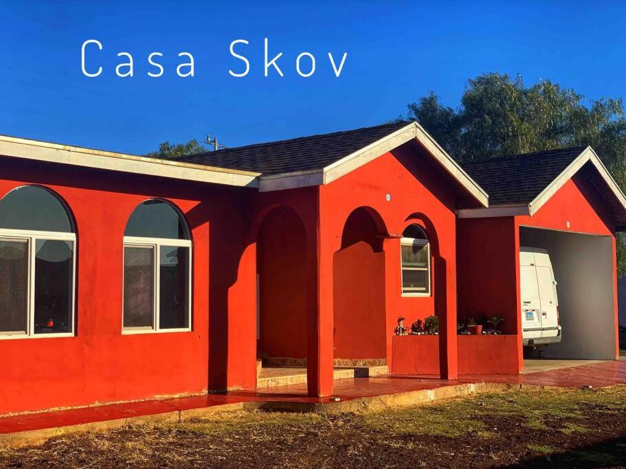 a red house with a black roof at San Quintin Casa Skov in Los Pinos