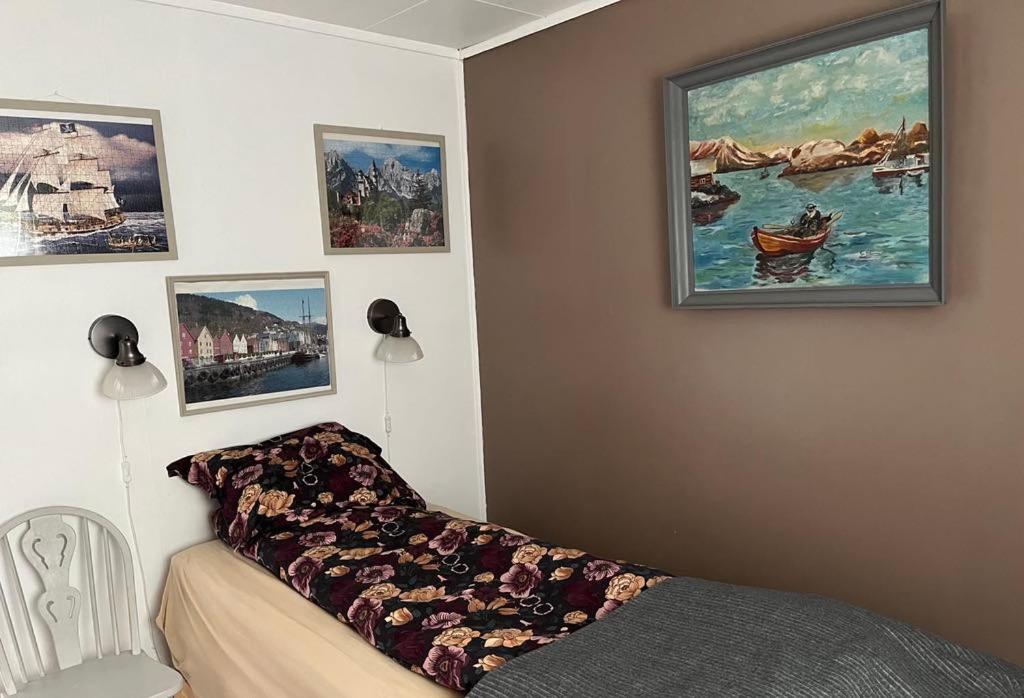 a bedroom with a couch and paintings on the wall at Holiday Home Sletta in Sletta