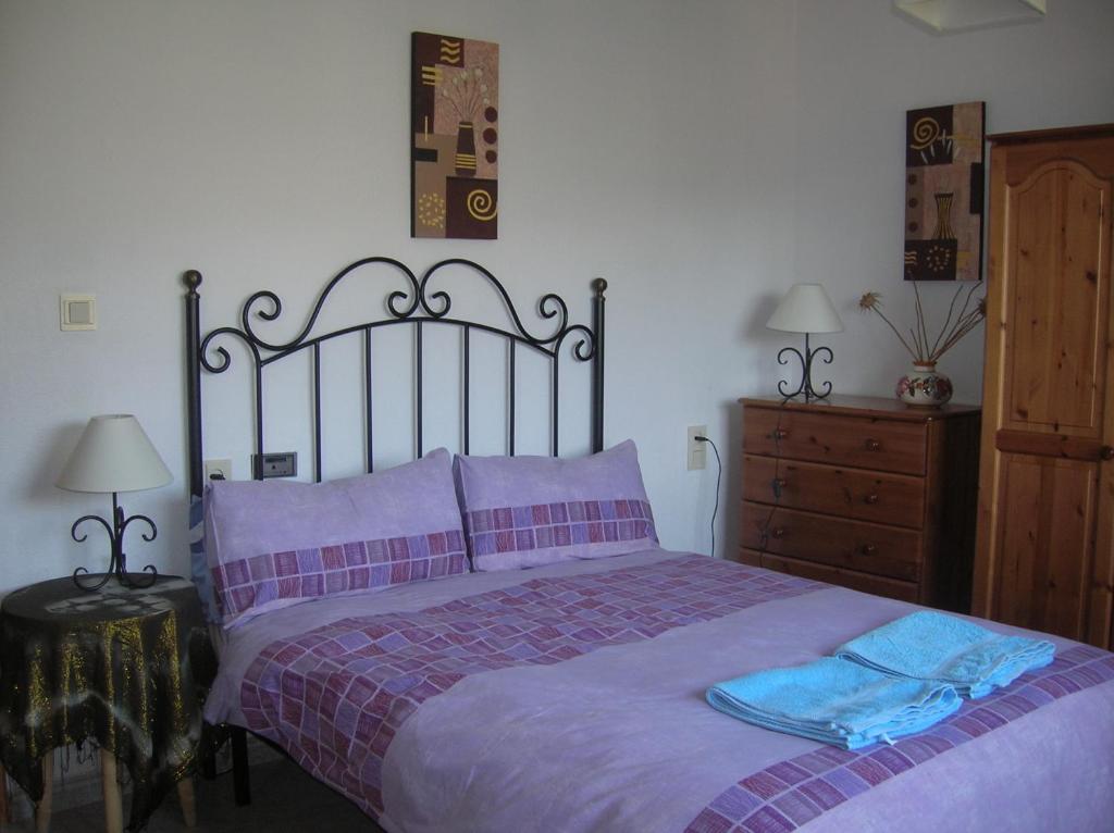 セネス・デ・ラ・ベガにあるCasa Ghaliaのベッドルーム1室(紫のシーツが敷かれた大型ベッド1台付)