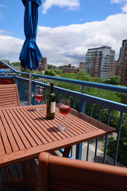 a wooden table with two glasses of wine on a balcony at ByWard Blue Inn in Ottawa