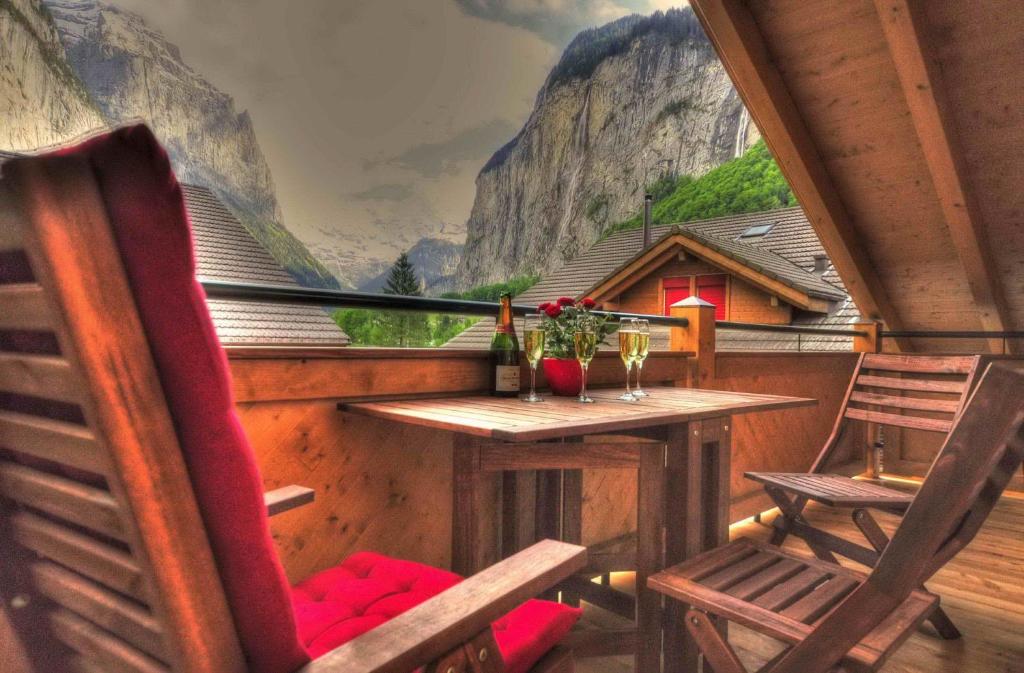 einen Tisch und Stühle auf einem Balkon mit Bergblick in der Unterkunft Luxury Penthouse Apartment in Lauterbrunnen