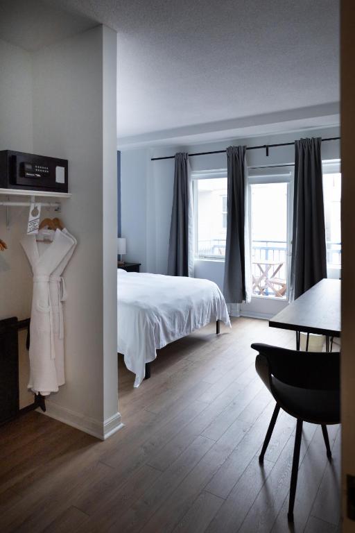 a bedroom with a bed and a table and window at ByWard Blue Inn in Ottawa