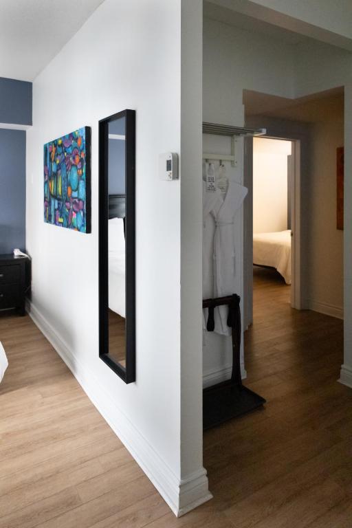 a white room with a mirror and a bedroom at ByWard Blue Inn in Ottawa