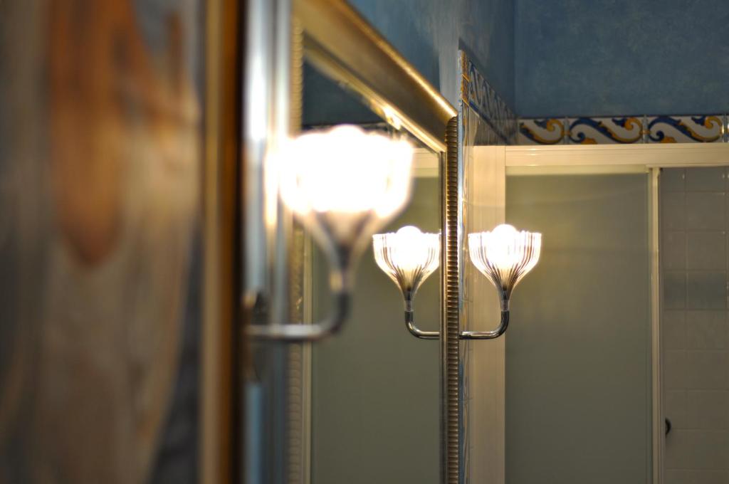 a mirror with two lights in front of a mirror at La Casa Del Pigneto in Rome