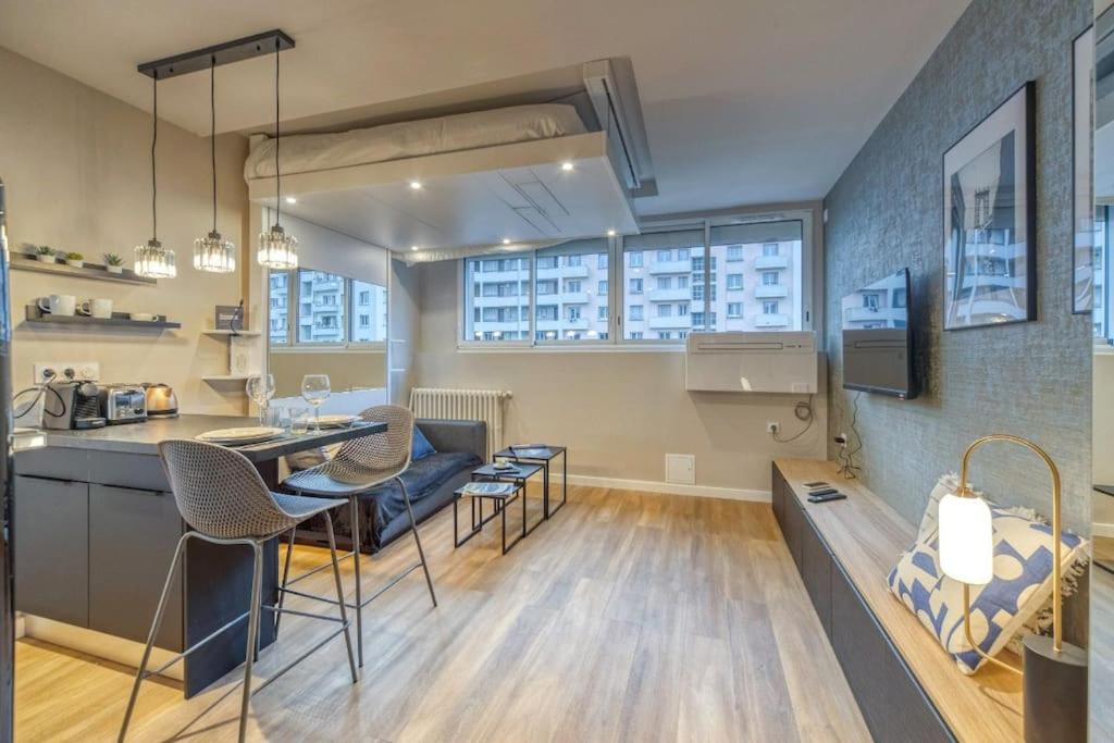 une cuisine et un salon avec une table et des chaises dans l'établissement R'Apparts Studio Le Luxury N6, à Grenoble