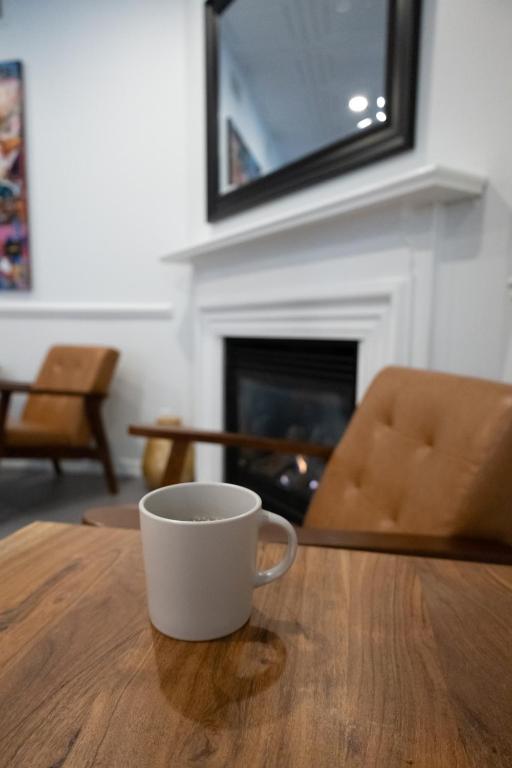 a coffee cup sitting on a wooden table with a fireplace at ByWard Blue Inn in Ottawa