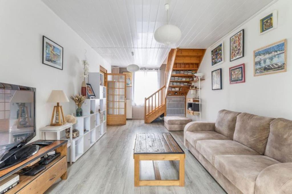 un salon avec un canapé et une table basse dans l'établissement Charmante maison avec jardin proche bordeaux, à Bègles