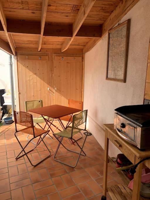 Cette chambre comprend une table, des chaises et une cuisinière. dans l'établissement Maisonnette centre de Fouras, à Fouras