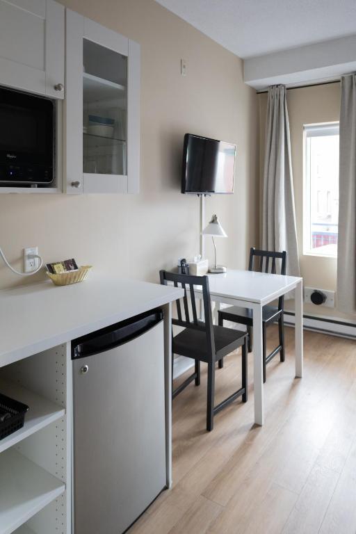 a kitchen and dining room with a white table and chairs at ByWard Blue Inn in Ottawa