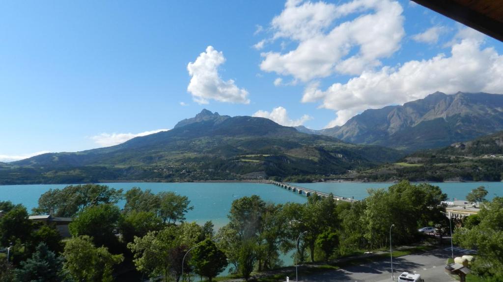 a view of a lake with mountains in the background at Hôtel les Chaumettes in Savines