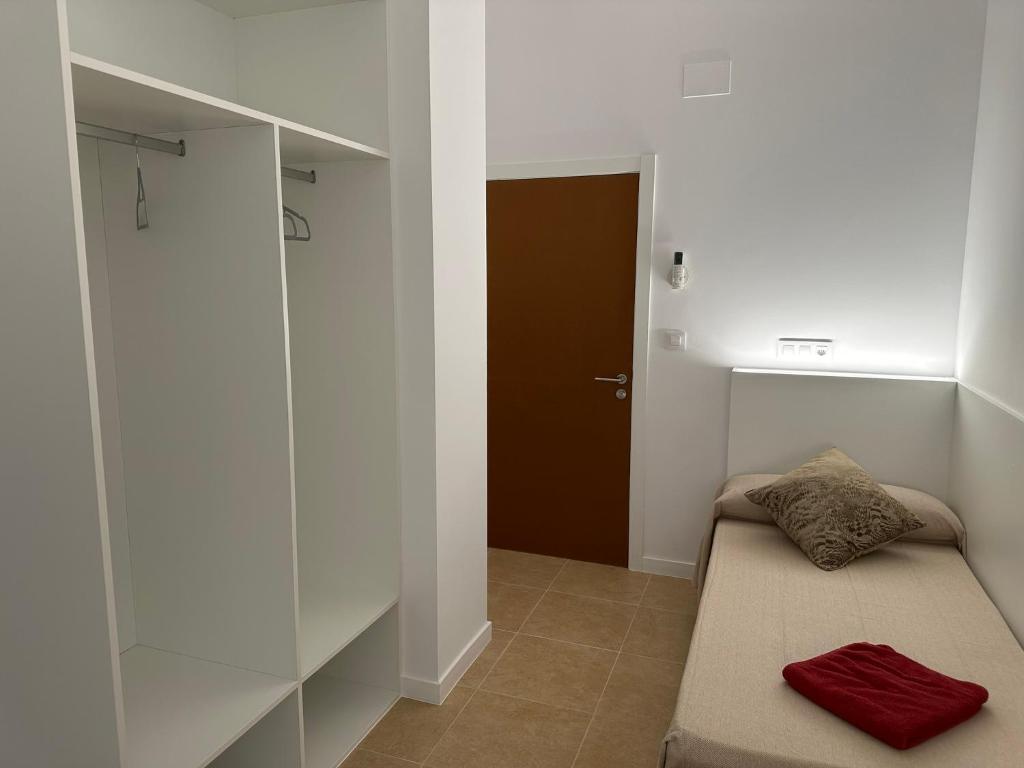 A bed or beds in a room at Albergue O Pedrón Hostel & Rooms