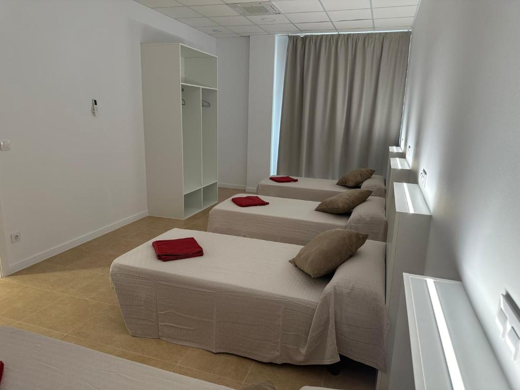 A bed or beds in a room at Albergue O Pedrón Hostel & Rooms