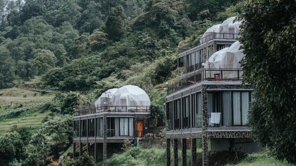 希萨鲁阿Damar Langit Resort的两栋山坡上带圆顶的建筑