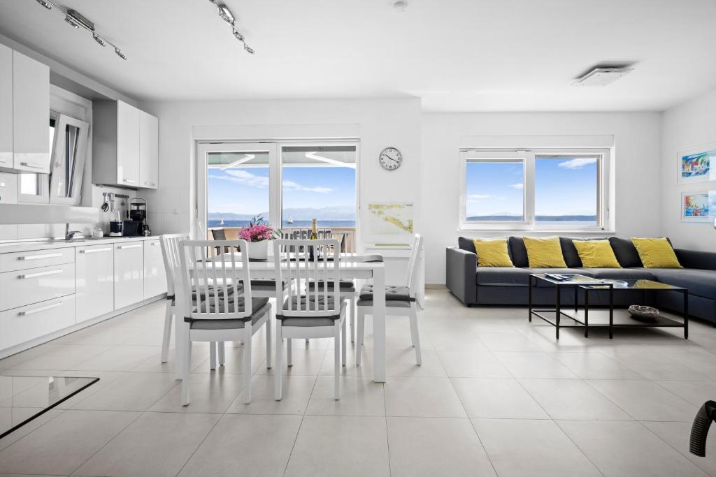 a white kitchen and living room with a table and chairs at House , Seafront Apartment Pelegrin in Stomorska