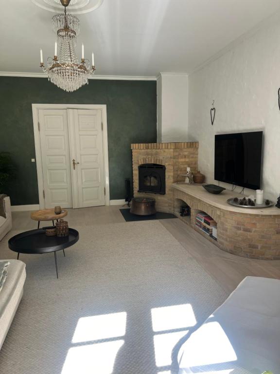a living room with a fireplace and a television at Lundtoftegaard in Kongens Lyngby