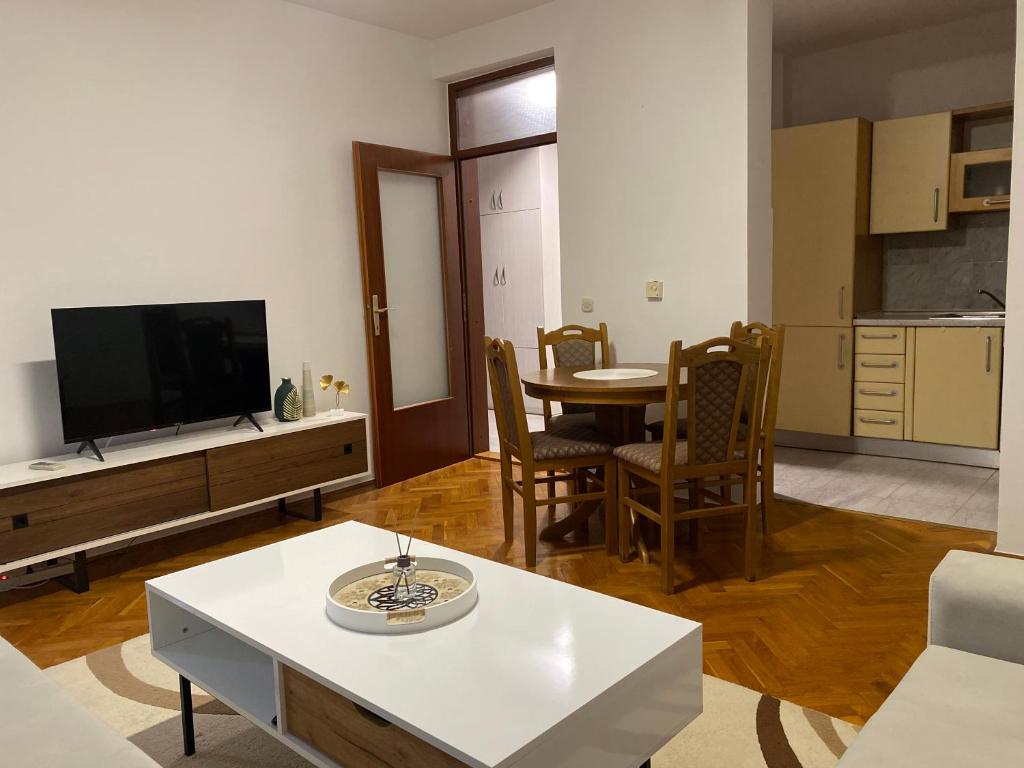 a living room with a tv and a table at Apartment Luka in Ljubuški
