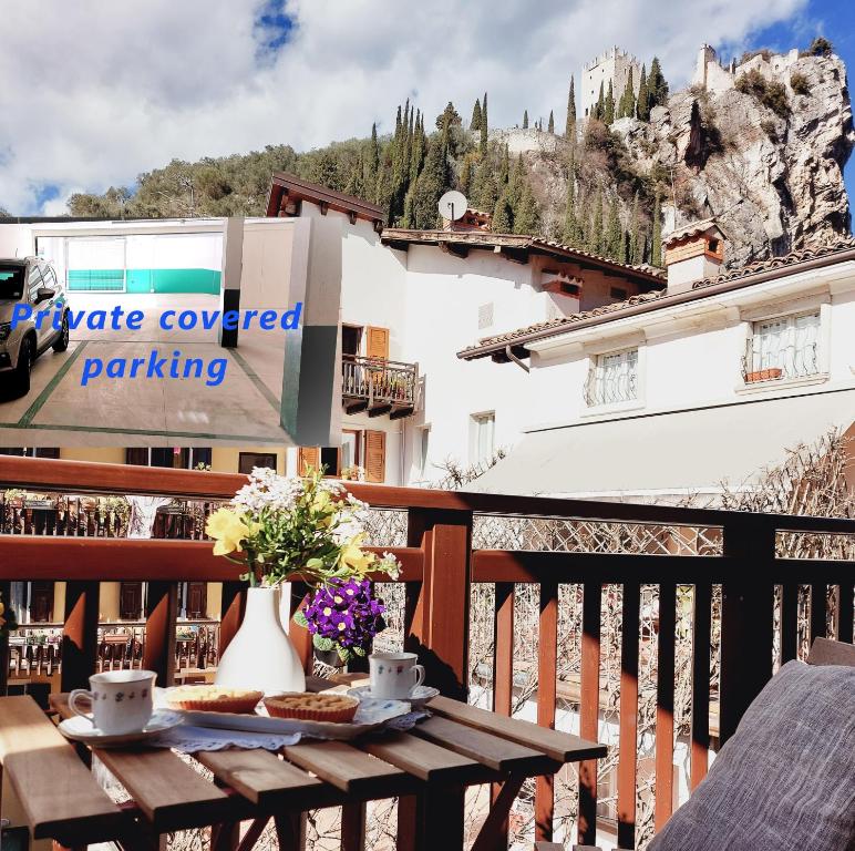 una mesa con comida y flores en el balcón en Arco Felix, en Arco