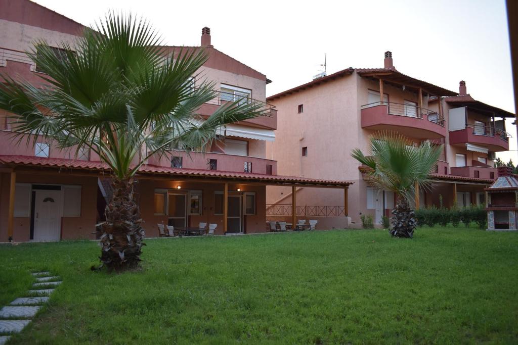 two palm trees in front of a building at IKIES LUXURY MAISONETTE HALKIDIKI Psakoudia in Psakoudia