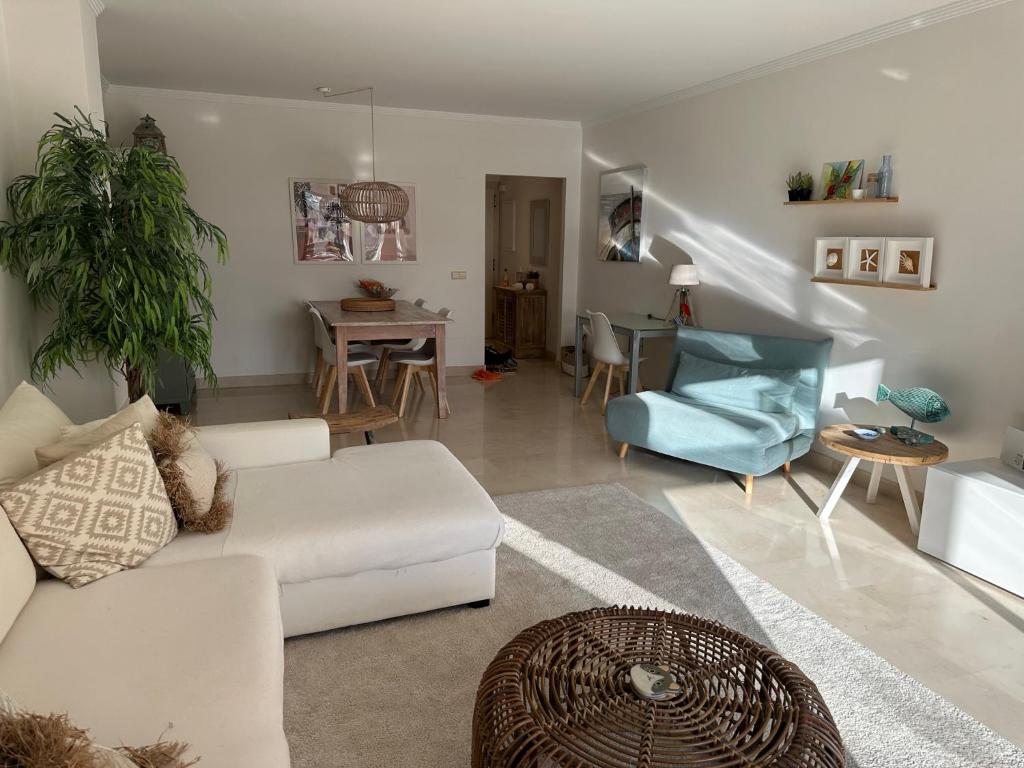 ein Wohnzimmer mit einer weißen Couch und einem blauen Stuhl in der Unterkunft Lovely apartment in Casares Beach in Casares