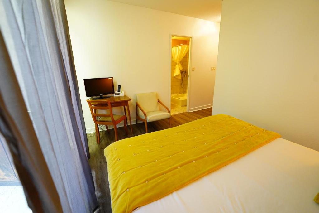 Postel nebo postele na pokoji v ubytování Logis Hôtel Le Griou