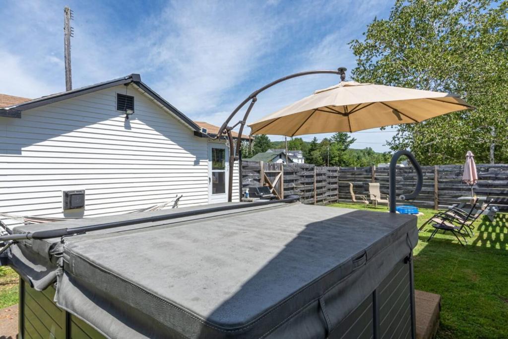 a patio with an umbrella next to a house at Mount Washington by Day Hot tub by night #2 in Carroll