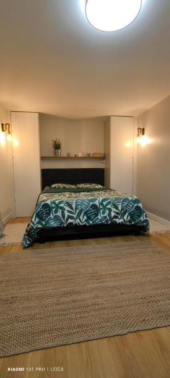 une chambre avec un lit avec une couverture dessus dans l'établissement Jolie studio, à Argenteuil