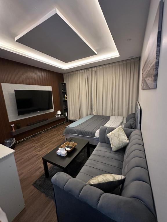 a living room with a couch and a tv at Studio with smart entry in Riyadh