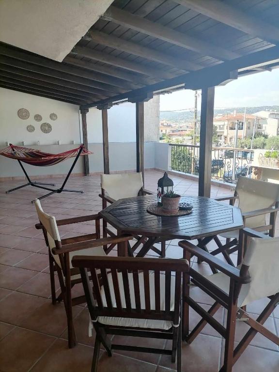 d'une terrasse avec une table, des chaises et un hamac. dans l'établissement Afroditi's House, à Nikiti