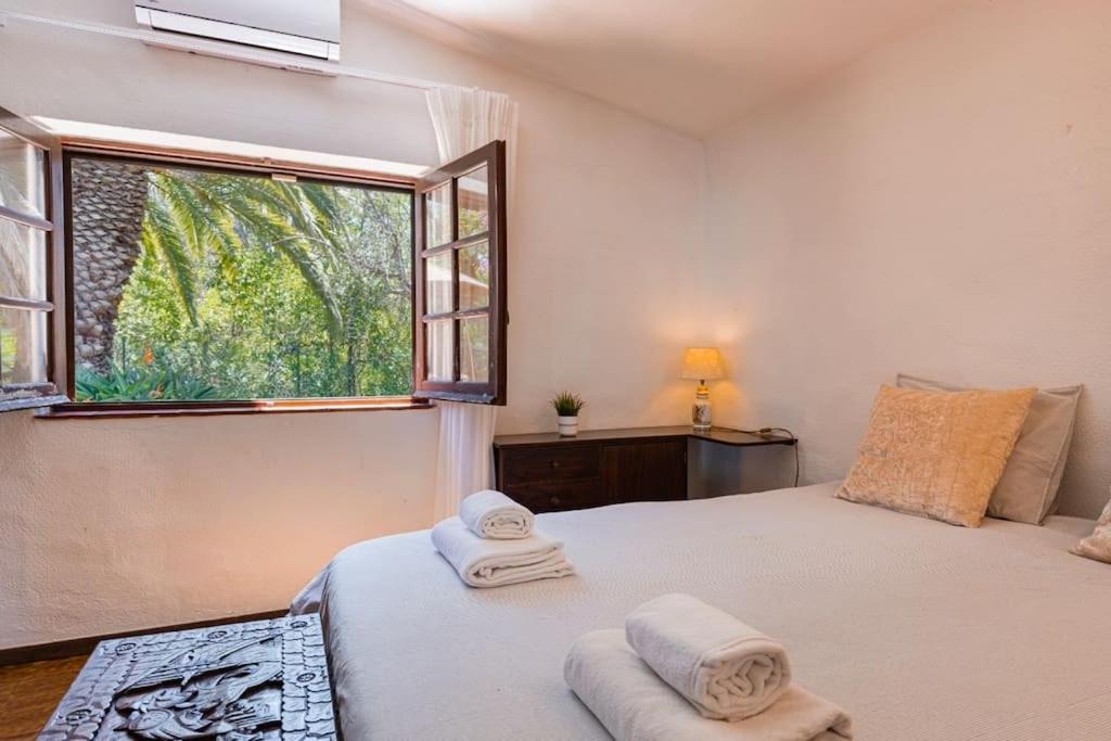 a bedroom with a bed and a window with towels at Charming swimming pool villa in Portimão