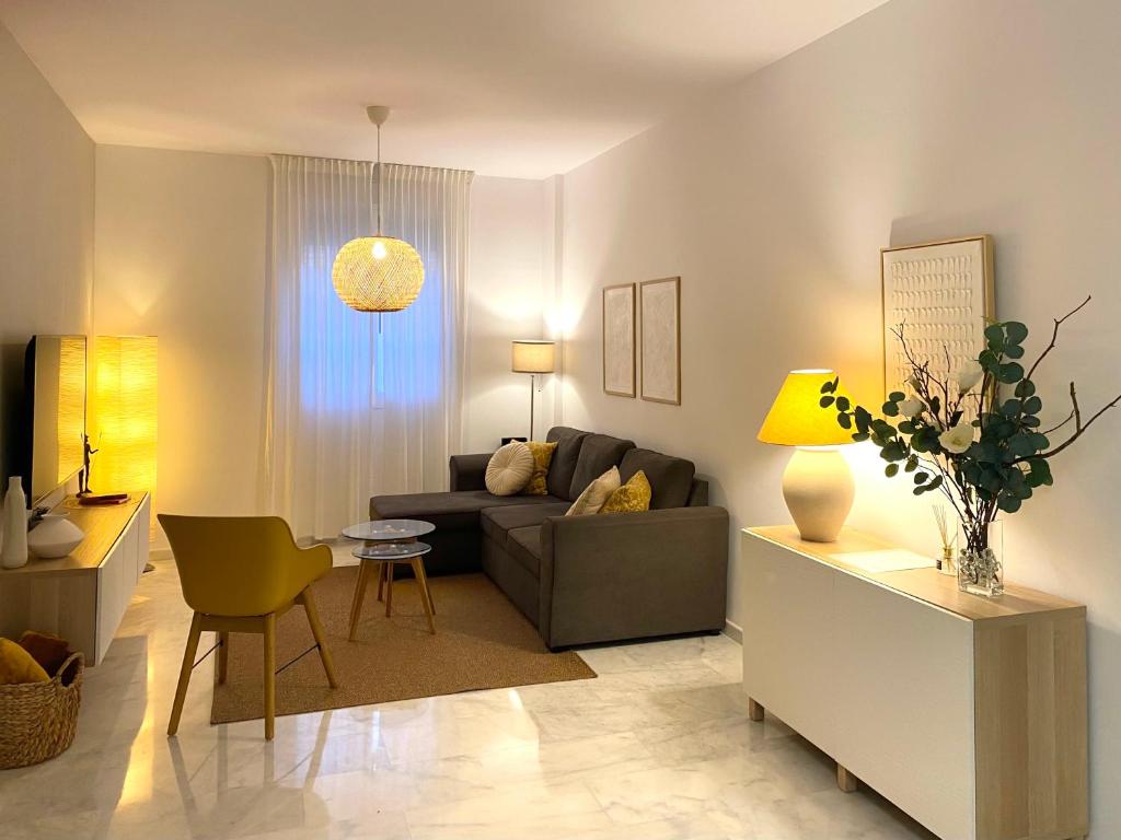 a living room with a couch and a table at KALUKA Málaga center apartment - free parking in Málaga