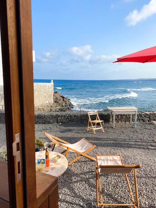 a view of a beach with two chairs and an umbrella at CA'MALÚ Estudio en el mar in Arrieta