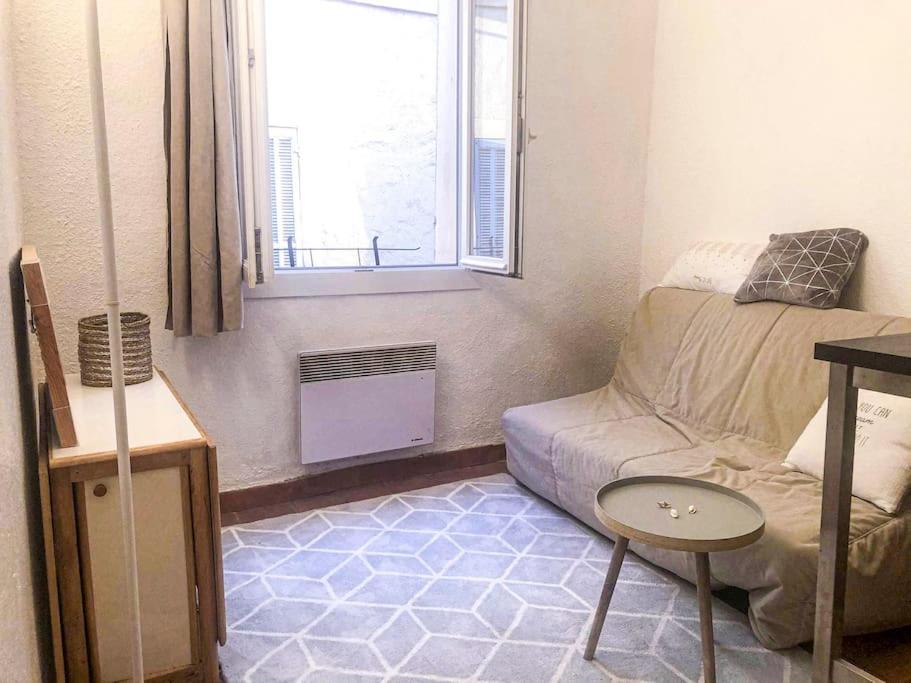 un salon avec un canapé et une fenêtre dans l'établissement Retraite provençale, charmant studio en cœur de ville, à Aix-en-Provence