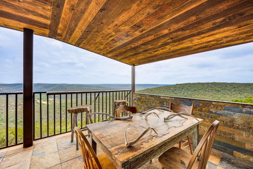 un tavolo in legno con sedie e un balcone con vista. di Scenic Leakey Vacation Rental with Private Patio! a Leakey