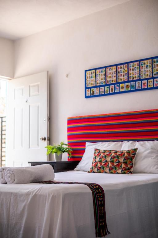 a bedroom with a large bed with a red and white headboard at Departamentos privados In Wotoch in Valladolid
