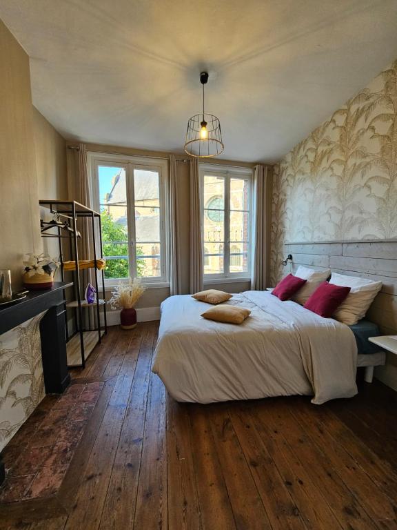 une chambre avec un grand lit blanc avec des oreillers rouges dans l'établissement Nid nature et douceur à Eu - Proche du Treport et de la Baie de Somme, à Eu