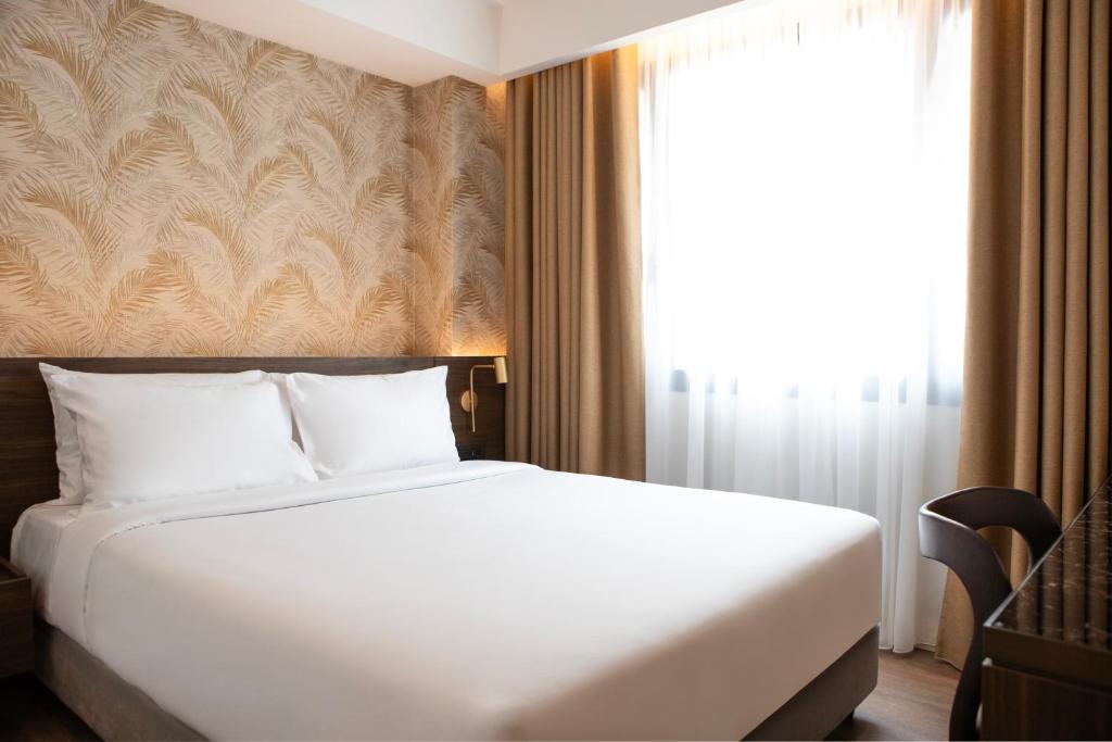 Postel nebo postele na pokoji v ubytování Luwian Athens Boutique Hotel