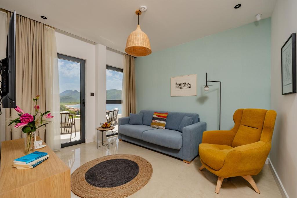 a living room with a blue couch and a chair at Hotel AQUILO in Petrovac na Moru