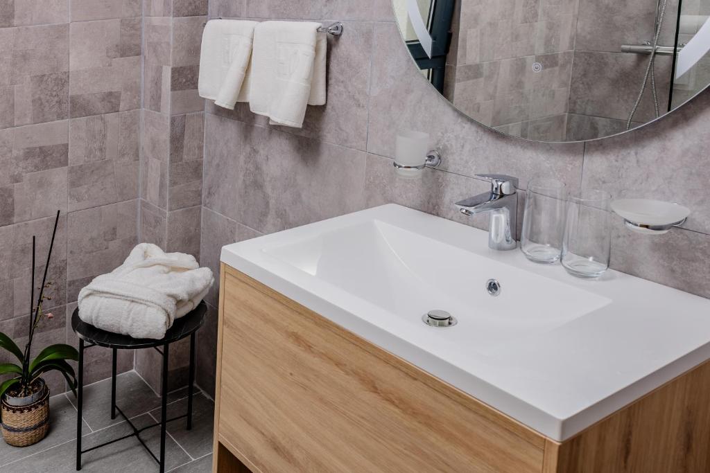 a bathroom with a white sink and a mirror at Hotel AQUILO in Petrovac na Moru