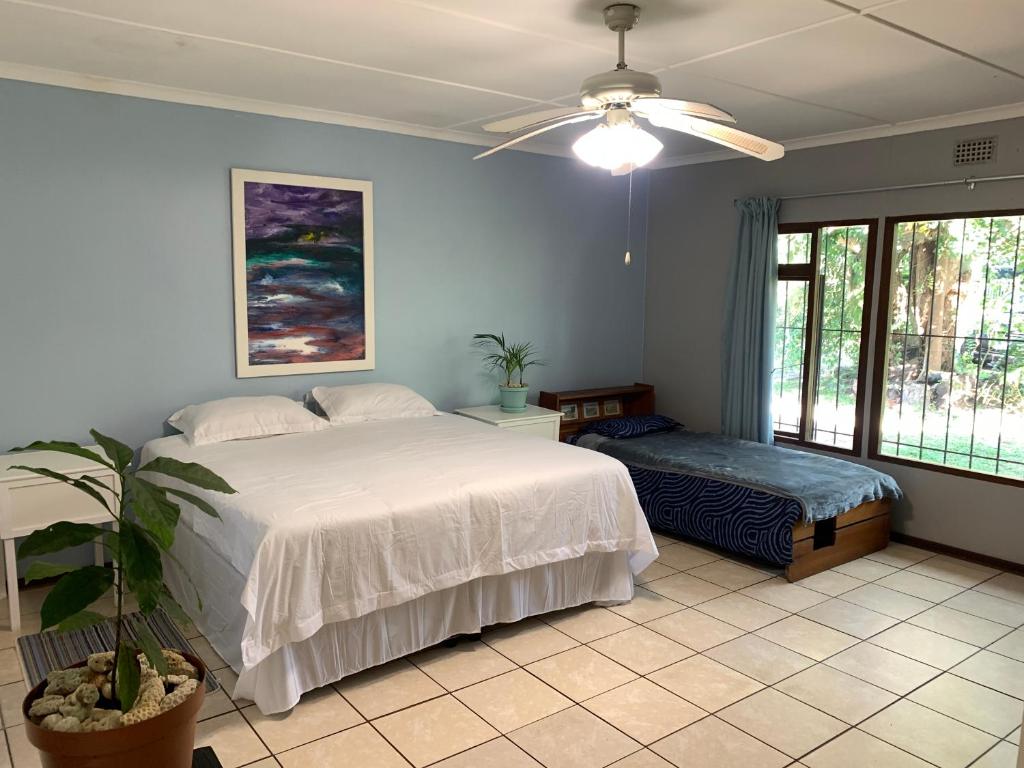 a bedroom with a large white bed and a window at Peace Cottage in St Lucia