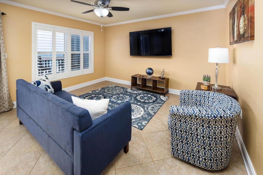 ein Wohnzimmer mit einer blauen Couch und einem Fernseher in der Unterkunft Islander 4006 in Fort Walton Beach