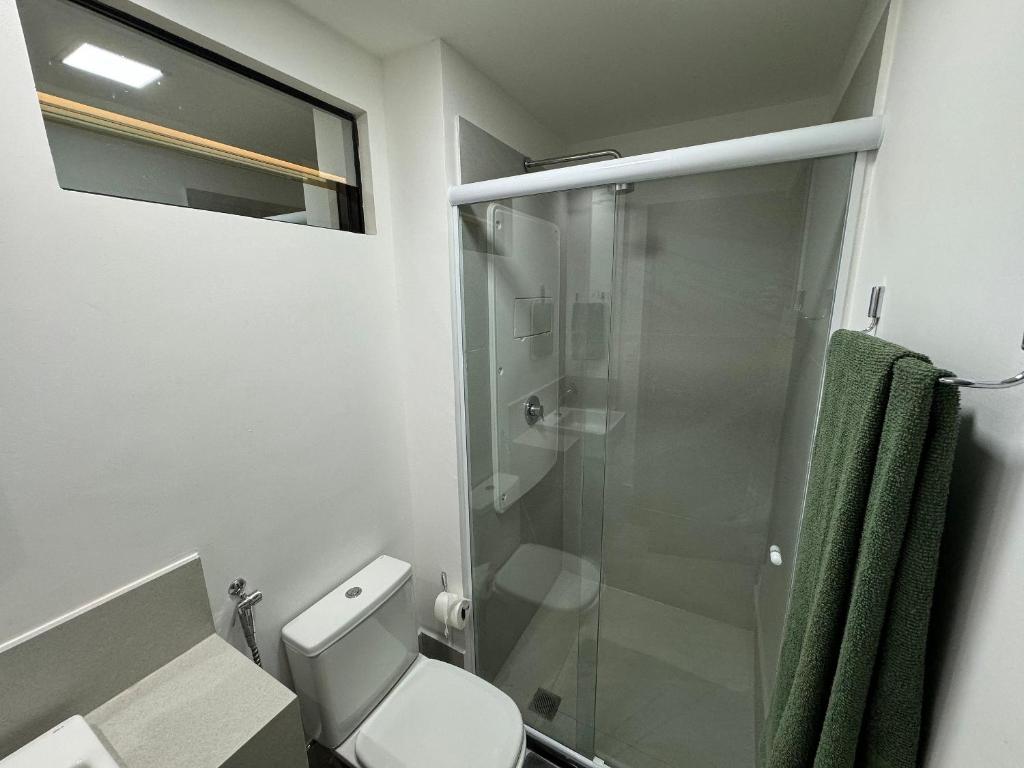 a bathroom with a toilet and a glass shower at 2 quartos a beira-mar do Cabo Branco AH103 Fortune in Tambaú