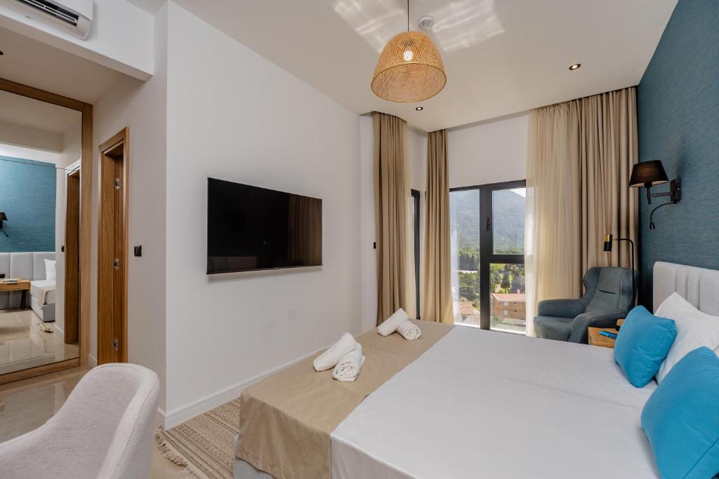 a hotel room with a large bed and a tv at Hotel AQUILO in Petrovac na Moru